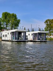 a couple of houses on a boat on a river at ARKA 2 - Houseboat w centrum Mielna, rower wodny, parking, Wi-Fi in Mielno
