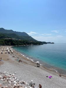 a group of people on a beach near the water at Aura Tower aparments by In Property in Rafailovici