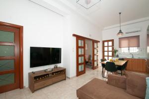 a living room with a flat screen tv on a wall at Vicinia Guest House in Rhodes Town