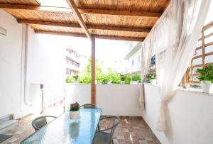 a patio with a glass table and chairs on a balcony at Vicinia Guest House in Rhodes Town