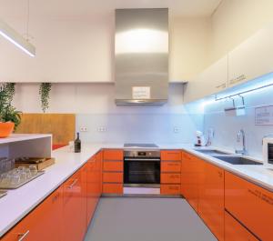 a kitchen with orange cabinets and a sink at Porto Lounge Hostel & Guesthouse in Porto
