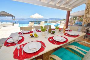 a white table with red napkins and food on it at Villa Helios Corfu Kassiopi in Kelliá