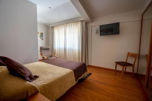 Habitación de hotel con cama y silla en Los Barruecos - BGA HOTELES, en Malpartida de Cáceres