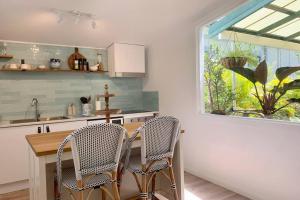 a kitchen with two chairs and a table and a window at Noraville Hamptons Style Beach House in Norah Head