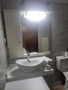 a bathroom with a sink and a mirror and a toilet at Zeus Apartman in Panagia +3 photos