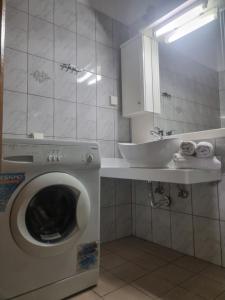 a bathroom with a washing machine and a sink at Zeus Apartman in Panagia