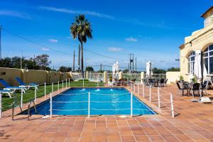 ein Schwimmbad mit einem Zaun um ihn herum in der Unterkunft Hotel Los Barruecos in Malpartida de Cáceres