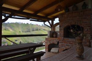 a room with a brick fireplace with a bench and a table at Pri stari preši in Lendava