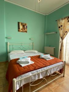 ein Schlafzimmer mit einem Bett mit einer orangefarbenen Decke in der Unterkunft Panagioula in Methana