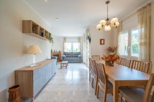 a dining room and living room with a table and chairs at Villa Mercedes in L'Escala