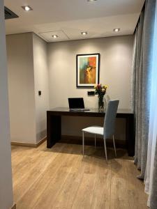 Ramada by Wyndham Downtown Beirut في بيروت: مكتب به مكتب وبه لاب توب وكرسي