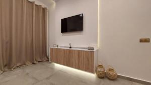 a living room with a television on a wall at Oasis in Kallithea Halkidikis