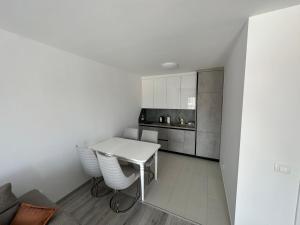 a white kitchen with a white table and chairs at BesTer Apartment in Ferizaj