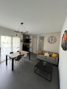 uma sala de estar com um sofá e uma mesa em LE TRESUM - Appartement + Garage - V-RENT em Annecy