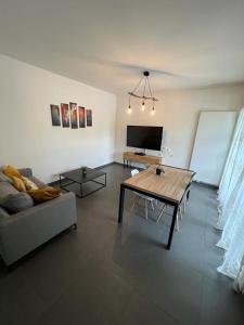uma sala de estar com uma mesa e um sofá em LE TRESUM - Appartement + Garage - V-RENT em Annecy