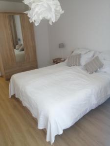1 dormitorio con 1 cama blanca grande con lámpara de araña en EASY RENT Apartments- Kazimierz Dolny Doły 4 lok 4 en Kazimierz Dolny