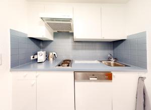 a white kitchen with a sink and white cabinets at Wohnhaus Christoph in Längenfeld