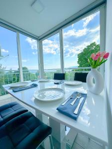 a white table with a vase of flowers on it at Luxury Apartman ASIA Rijeka in Rijeka