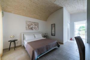 sypialnia z łóżkiem i dużym oknem w obiekcie B&B Villa Vittoria Ostuni w mieście Ostuni