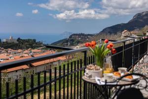 a table with flowers on a balcony with a view at Agriturismo Punta San Lazzaro in Agerola