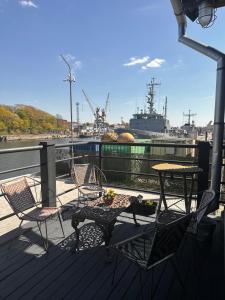 a table and chairs on a deck with a ship at Fontaine Mansion in Liepāja