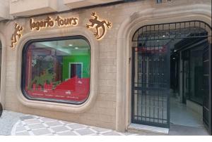 un frente de tienda con una ventana con un cartel en Centrico alojamiento, en Jaén