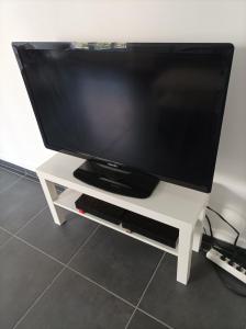 uma televisão de ecrã plano num suporte de televisão branco em O'Couvent - Appartement 91 m2 - 4 chambres - A521 em Salins-les-Bains