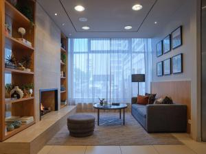 a living room with a couch and a fireplace at Adina Apartment Hotel Berlin Checkpoint Charlie in Berlin