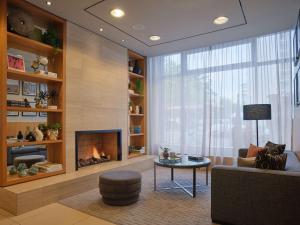 a living room with a fireplace and a couch at Adina Apartment Hotel Berlin Checkpoint Charlie in Berlin
