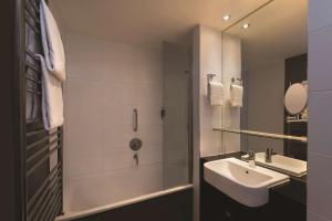 a bathroom with a tub and a sink and a shower at Adina Apartment Hotel Berlin Checkpoint Charlie in Berlin