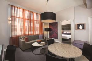 a living room with a couch and a table at Adina Apartment Hotel Berlin Checkpoint Charlie in Berlin