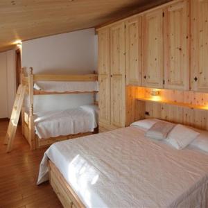 sypialnia z 2 łóżkami i drewnianymi ścianami w obiekcie B&B La Soldanella w mieście Santo Stefano dʼAveto