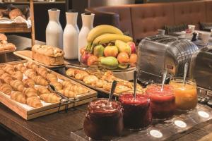 a buffet with different types of pastries and fruit at Adina Apartment Hotel Hamburg Speicherstadt in Hamburg
