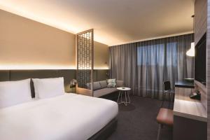 a hotel room with a white bed and a couch at Adina Apartment Hotel Hamburg Speicherstadt in Hamburg +29 photos