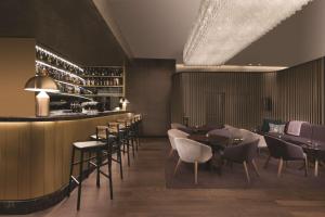 a restaurant with tables and chairs and a bar at Adina Apartment Hotel Nuremberg in Nuremberg