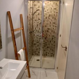uma casa de banho com um chuveiro e um lavatório. em Ancoradouro T2 - Alojamento Local Gerês em Braga