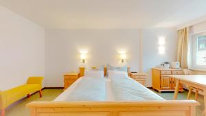 a bedroom with a large bed with blue sheets at Zimmer Enzian in Längenfeld