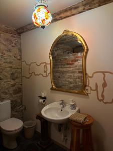 a bathroom with a sink and a mirror and a toilet at Fontaine Mansion in Liepāja