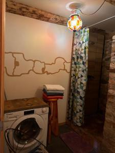 a laundry room with a washing machine and a chandelier at Fontaine Mansion in Liepāja