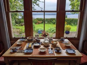 una mesa de madera con comida delante de una ventana en Black Isle Bed and Breakfast en Avoch