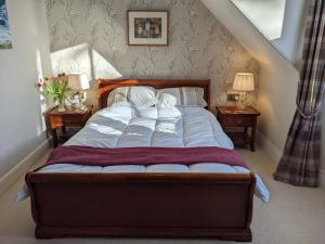 a bed in a bedroom with two nightstands and two lamps at Black Isle Bed and Breakfast in Avoch