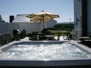 einen Whirlpool mit einem Tisch und einem Sonnenschirm in der Unterkunft A Awesome Shenandoah Valley View in Elkton