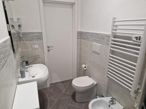 Baño blanco con aseo y lavamanos en giuchi home casa vacanze, en Avola