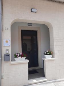 un edificio con dos macetas de flores delante de una puerta en giuchi home casa vacanze, en Avola