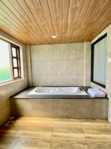 a bath tub in a bathroom with a wooden ceiling at Ambrosia Resort in Alibaug
