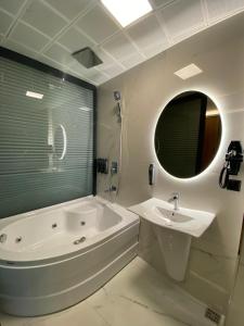 a white bathroom with a tub and a sink at Gumus Palace Gungoren in Istanbul