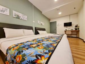 Treeline Urban Inn في كوتا كينابالو: غرفة نوم مع سرير كبير مع بطانية ملونة