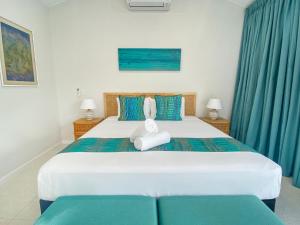 Picnic Bay的住宿－Rock Salt Villa 1，卧室配有一张带蓝色窗帘的大型白色床