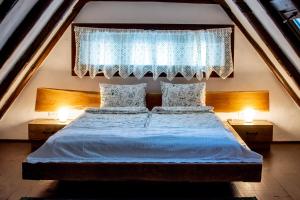 1 dormitorio con 1 cama con 2 lámparas y una ventana en Casa Boierului Comanici 