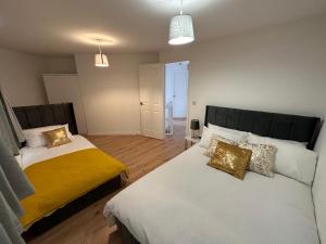 a bedroom with two beds and a hallway at Trinity's Place in Wythenshawe